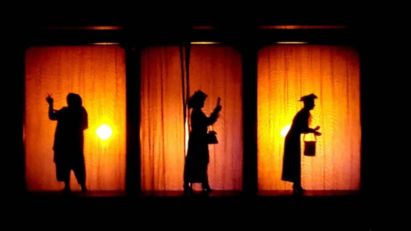 Three silhouetted figures lit against glowing orange panels, representing real-time event content at Growth Yogi