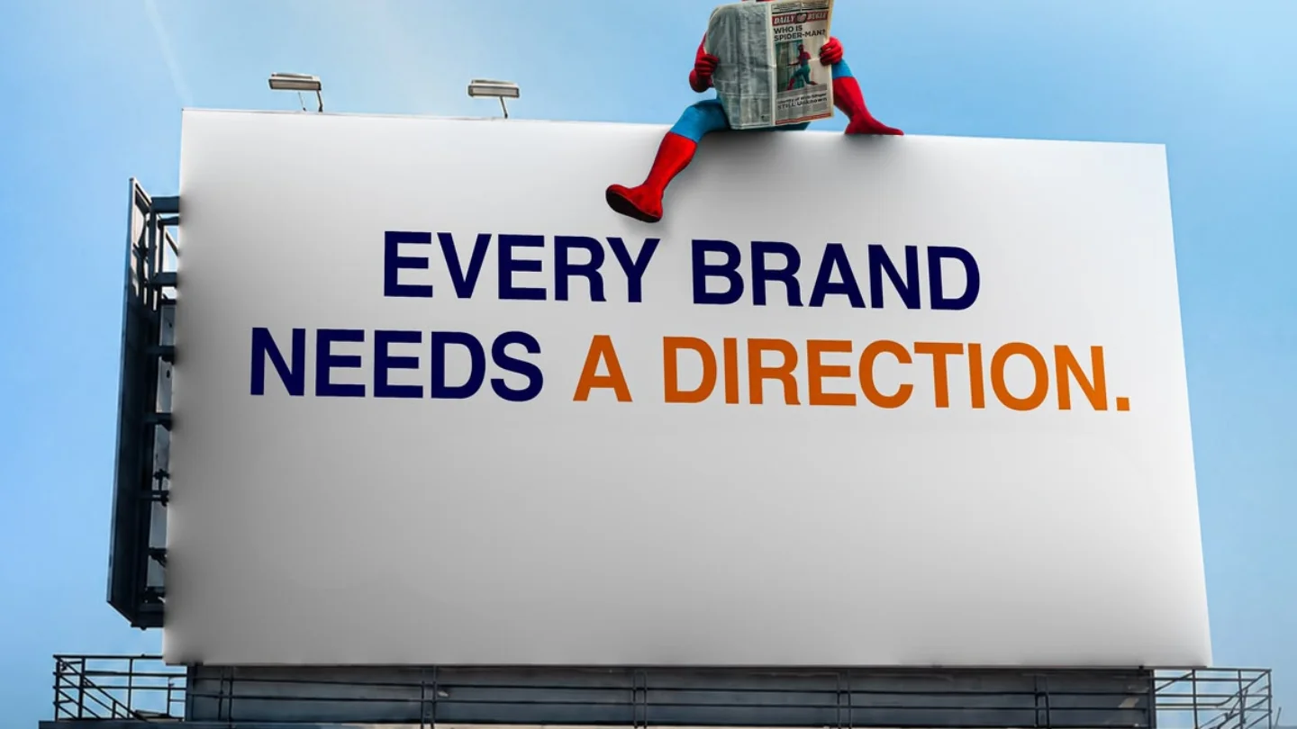 Billboard reading Every brand needs a direction with a figure sitting on top, representing through-the-line campaigns at Growth Yogi